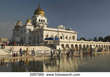 Stock Photography - Worshippers at the Gurudwara Bangla Sahib, a Sikh temple in Delhi. Gurudwara Bangla Sahib is the most prominent Sikh gurdwara in Delhi. The temple has a fine golden cupola and a sacred pool of water known as the Saroyar. The holy shrine was constructed. Fotosearch