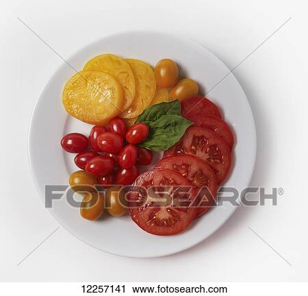 Stock Image - Yellow and red tomatoes on a plate. Fotosearch