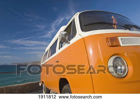 Stock Image - Yellow Camper Van By Sea, Sennen Cove, Cornwall, England. Fotosearch