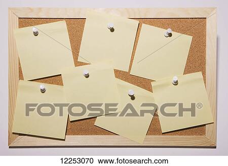 Stock Image - Yellow notes pinned to a cork board. Fotosearch