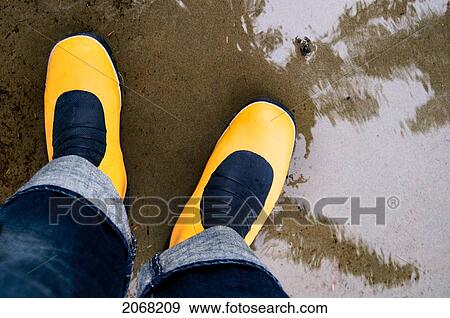 Stock Photo - Yellow Rain Boots In Water With A Reflection; Tofino British Columbia Canada. Fotosearch