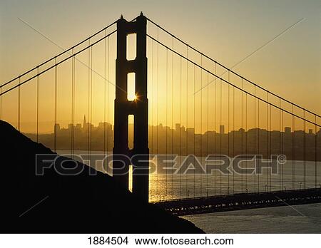 Picture - Yellow Sunrise Behind The Golden Gate Bridge With Skyline Behind. Fotosearch