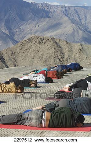 Stock Image - Yoga 'salutation to the sun' performed in front of the Shanti (Peace) Stupa overlooking Leh. Ladakh, Province of Jammu and Kashmir, India. Fotosearch