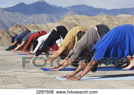 Stock Photo - Yoga 'salutation to the sun' performed in front of the Shanti (Peace) Stupa overlooking Leh. Ladakh, Province of Jammu and Kashmir, India. Fotosearch
