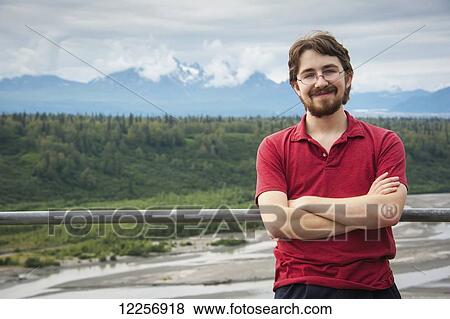 Stock Photo - Young adult posing in front of the Susitna River, Southcentral Alaska. Fotosearch