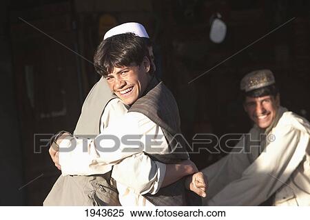 Stock Photography - Young Afghan Men Wrestling In A Store In Jalrez, Vardak Province, Afghanistan. Fotosearch