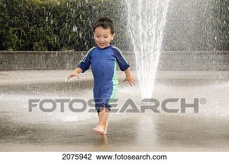 Young Asian-Caucasian Boy Playing In A Water Sprinkler; Ontario Canada View Large Photo Image Stock Image - Young Asian-Caucasian Boy Playing In A Water Sprinkler; Ontario Canada. Fotosearch