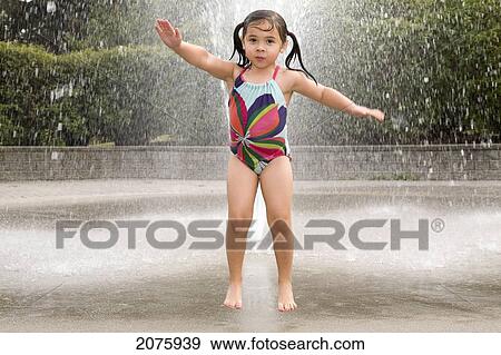 Young Asian-Caucasian Girl Jumping And Playing In A Water Sprinkler; Ontario Canada View Large Photo Image Stock Photo - Young Asian-Caucasian Girl Jumping And Playing In A Water Sprinkler; Ontario Canada. Fotosearch