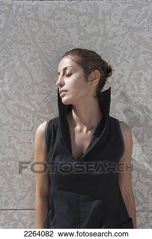 Stock Image - Young Attractive Iranian Woman Wearing Stylish Clothing Against A Concrete Wall; Winnipeg Manitoba Canada. Fotosearch