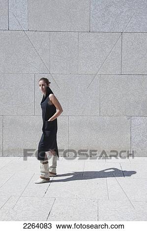 Stock Image - Young Attractive Iranian Woman Wearing Stylish Clothing Against A Concrete Wall; Winnipeg Manitoba Canada. Fotosearch