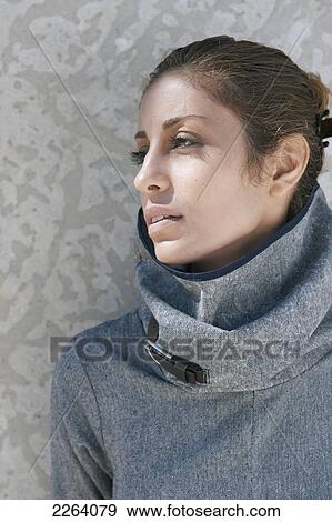 Stock Photo - Young Attractive Iranian Woman Wearing Stylish Clothing Against A Concrete Wall; Winnipeg Manitoba Canada. Fotosearch
