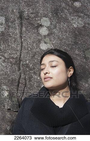 Stock Image - Young Attractive Mexican Woman Standing Against A Large Rock Wall; Huntsville Ontario Canada. Fotosearch