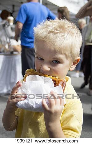 Stock Image - Young Boy Eating Pastry; Ladner British Columbia Canada. Fotosearch