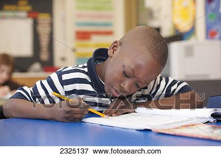 Stock Photo - Young Boy In Grade 3 Working At His Desk In Classroom, Toronto, Ontario, Canada. Fotosearch