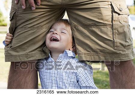 Young Boy Laughing And Hugging His Dad's Legs; Ontario Canada View Large Photo Image Stock Photography - Young Boy Laughing And Hugging His Dad's Legs; Ontario Canada. Fotosearch