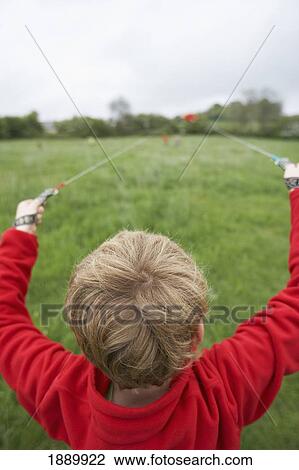 Young Boy Launching Red Kite In A Grassy Field View Large Photo Image Stock Image - Young Boy Launching Red Kite In A Grassy Field. Fotosearch