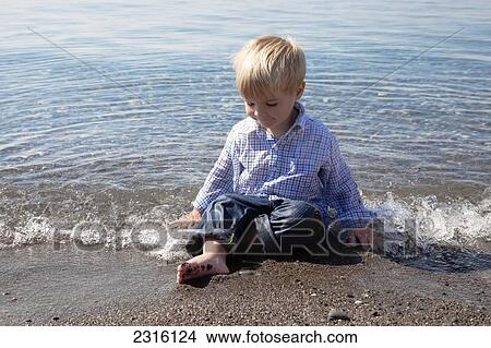 Young Boy Playing In The Waves At The Beach By Lake Ontario; Ontario Canada View Large Photo Image Picture - Young Boy Playing In The Waves At The Beach By Lake Ontario; Ontario Canada. Fotosearch
