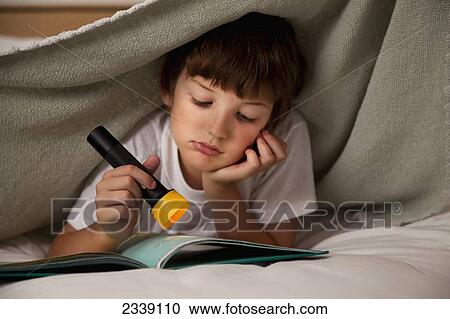 Young Boy Reading Under The Covers With A Flashlight; San Francisco, California, Canada View Large Photo Image Stock Image - Young Boy Reading Under The Covers With A Flashlight; San Francisco, California, Canada. Fotosearch