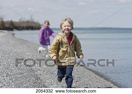Young Boy Running Ahead Of Young Girl On Pebble Beach Of Lake Ontario, Ontario View Large Photo Image Stock Image - Young Boy Running Ahead Of Young Girl On Pebble Beach Of Lake Ontario, Ontario. Fotosearch