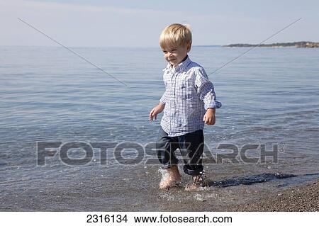 Young Boy Running Through The Waves At The Beach By Lake Ontario; Ontario Canada View Large Photo Image Picture - Young Boy Running Through The Waves At The Beach By Lake Ontario; Ontario Canada. Fotosearch