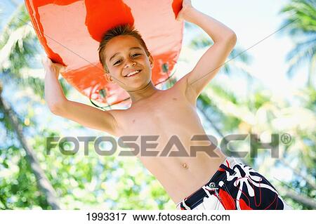 Stock Photo - Young Boy Smiling With Bright Red Surfboard. Fotosearch