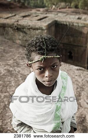 Stock Photograph - Young boy wearing a traditional grass headband for Orthodox Easter; Lalibela, Ethiopia. Fotosearch