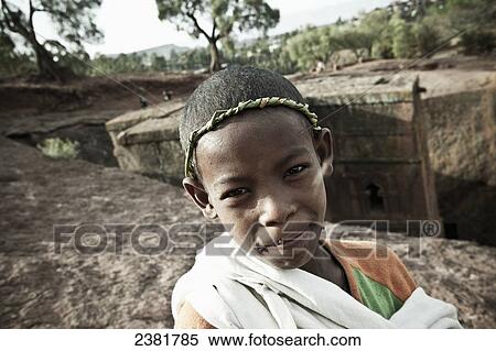 Stock Photography - Young boy wearing a traditional grass headband for Orthodox Easter; Lalibela, Ethiopia. Fotosearch