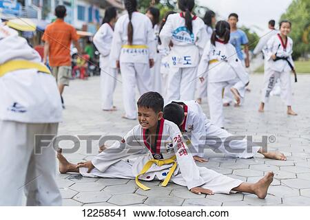 Young boy with strained expression on his face, stretching hard in Tae Kwon Do class; Battambang, Cambodia View Large Photo Image Stock Image - Young boy with strained expression on his face, stretching hard in Tae Kwon Do class; Battambang, Cambodia. Fotosearch