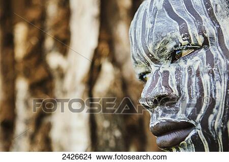 Picture - Young boy with traditional painted face, paint made from natural ground river stones, Omo region, Southwest Ethiopia; Kibish, Ethiopia. Fotosearch