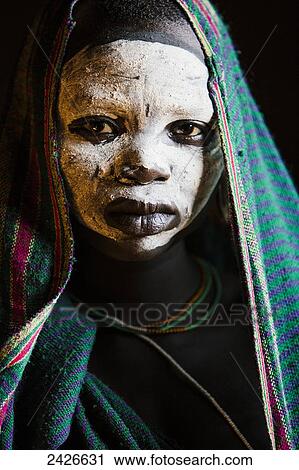 Stock Image - Young boy with traditional painted face, paint made from natural ground river stones, Omo region, Southwest Ethiopia; Kibish, Ethiopia. Fotosearch