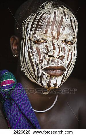 Stock Photograph - Young boy with traditional painted face, paint made from natural ground river stones, Omo region, Southwest Ethiopia; Kibish, Ethiopia. Fotosearch