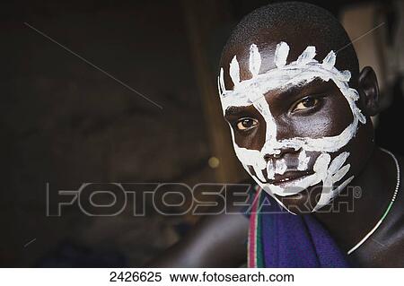Young boy with traditional painted face, paint made from natural ground river stones, Omo region, Southwest Ethiopia; Kibish, Ethiopia View Large Photo Image Stock Photography - Young boy with traditional painted face, paint made from natural ground river stones, Omo region, Southwest Ethiopia; Kibish, Ethiopia. Fotosearch