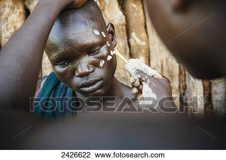 Stock Image - Young boys with traditional painted faces, paint made from natural ground river stones, Omo region, Southwest Ethiopia; Kibish, Ethiopia. Fotosearch