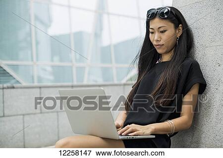 Young businesswoman working on her laptop computer; Xiamen, China View Large Photo Image Stock Photo - Young businesswoman working on her laptop computer; Xiamen, China. Fotosearch