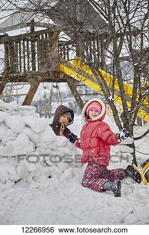 Young Caucasian kids building a snow fort in the backyard; Ontario, Canada View Large Photo Image Stock Photograph - Young Caucasian kids building a snow fort in the backyard; Ontario, Canada. Fotosearch
