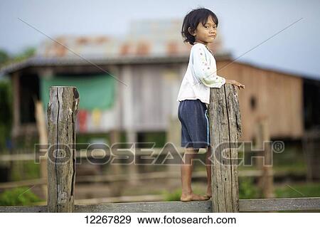 Young child walking on wooden fence; Mondulkiri, Cambodia View Large Photo Image Stock Photo - Young child walking on wooden fence; Mondulkiri, Cambodia. Fotosearch