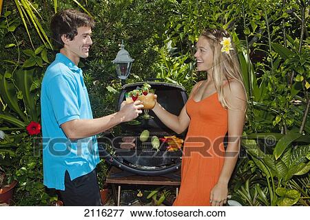 Stock Photo - Young couple at an oudoor barbeque lunch in a Hawaiian garden.. Fotosearch