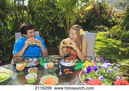 Young couple at an oudoor barbeque lunch in a Hawaiian garden. View Large Photo Image Stock Photo - Young couple at an oudoor barbeque lunch in a Hawaiian garden.. Fotosearch