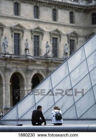 Stock Image - Young Couple Beside The Pyramid In The Courtyard Of Louvre. Fotosearch