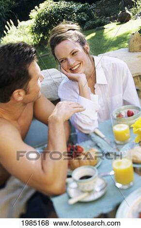 Young couple enjoying breakfast in outdoor setting View Large Photo Image Stock Photo - Young couple enjoying breakfast in outdoor setting. Fotosearch