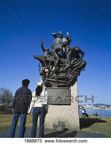 Stock Image - Young Couple Looking Up At A Statue Commemorating Sailors On Bygdoy Peninsula.. Fotosearch