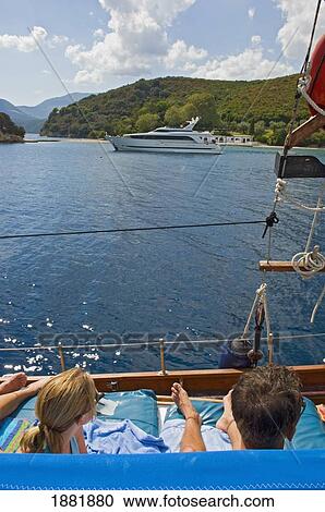 Young Couple Relaxing Deck Of Yacht Sailing Near The Island Lefkas. View Large Photo Image Stock Image - Young Couple Relaxing Deck Of Yacht Sailing Near The Island Lefkas.. Fotosearch