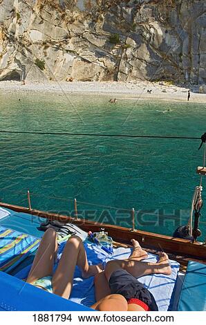 Young Couple Relaxing On Yacht Near A Beach In Ionian Sea. View Large Photo Image Picture - Young Couple Relaxing On Yacht Near A Beach In Ionian Sea.. Fotosearch