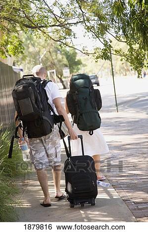 Young Couple Walking Down Street With Backpacks And Suitcase View Large Photo Image Stock Photograph - Young Couple Walking Down Street With Backpacks And Suitcase. Fotosearch