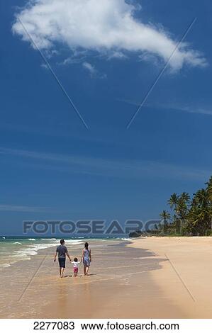 Stock Image - Young family on beach on south coast near Unawatuna; Sri Lanka. Fotosearch