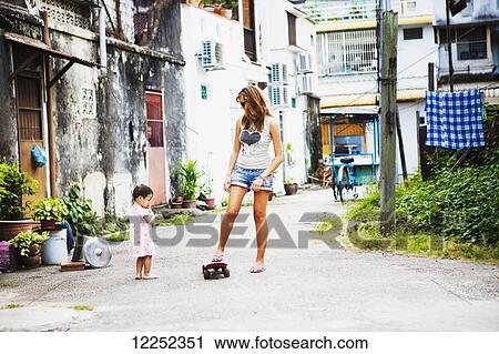 Young female tourist with a skateboard on a downtown street; Penang, Malaysia View Large Photo Image Stock Image - Young female tourist with a skateboard on a downtown street; Penang, Malaysia. Fotosearch