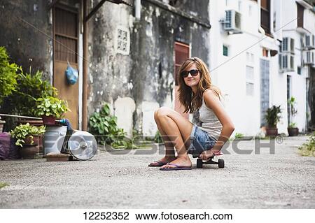 Young female tourist with a skateboard on a downtown street; Penang, Malaysia View Large Photo Image Stock Image - Young female tourist with a skateboard on a downtown street; Penang, Malaysia. Fotosearch