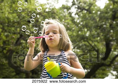 Stock Image - Young Girl Blowing Bubbles; Ontario Canada. Fotosearch