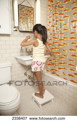 Stock Photo - Young Girl Brushing Her Teeth In The Bathroom; San Francisco, California, Usa. Fotosearch