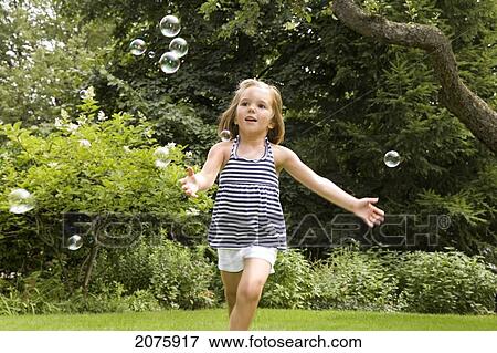 Young Girl Chasing Floating Bubbles; Ontario Canada View Large Photo Image Stock Photo - Young Girl Chasing Floating Bubbles; Ontario Canada. Fotosearch